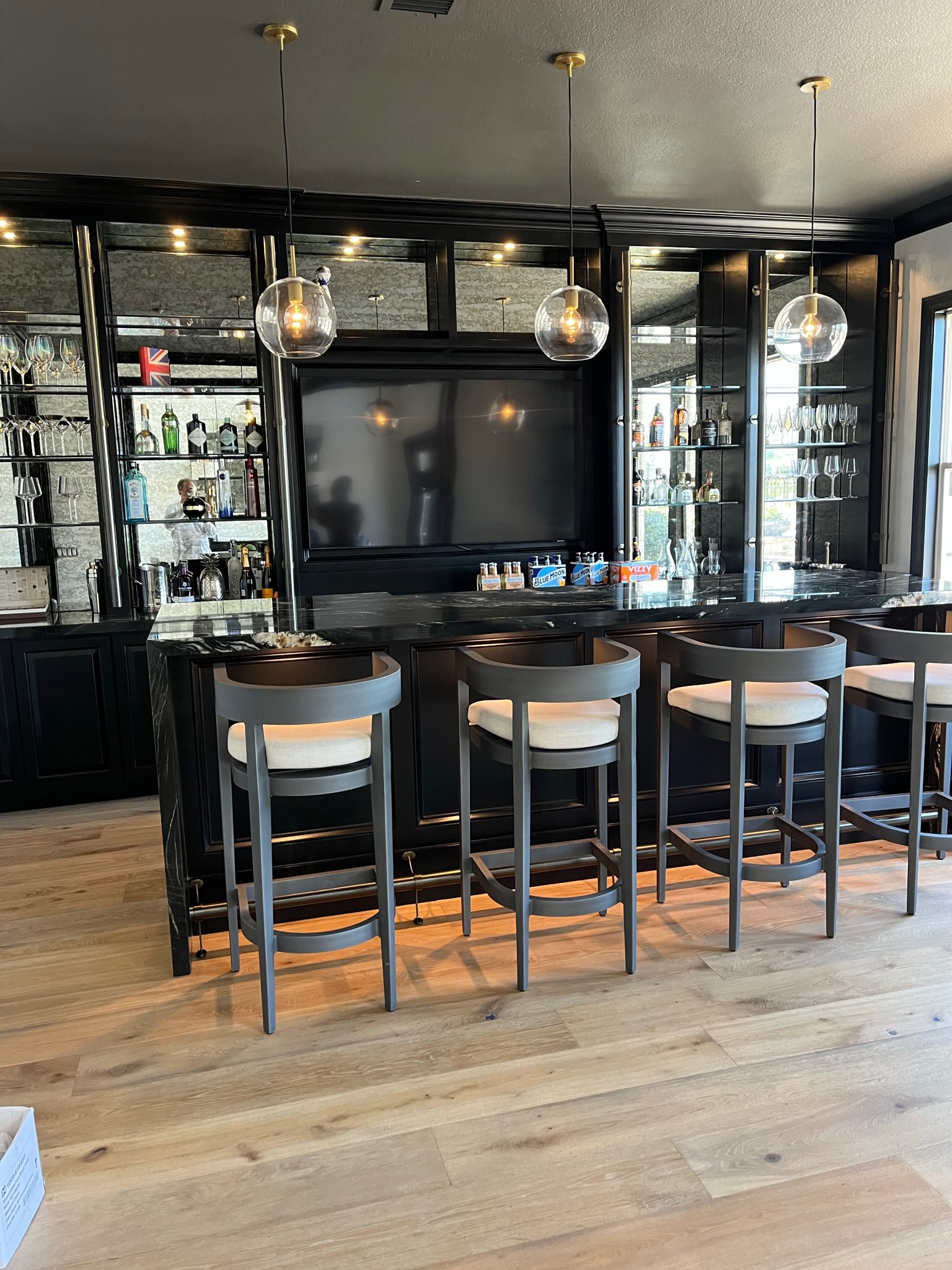 Black lacquer bar with mirrored shelving and stools