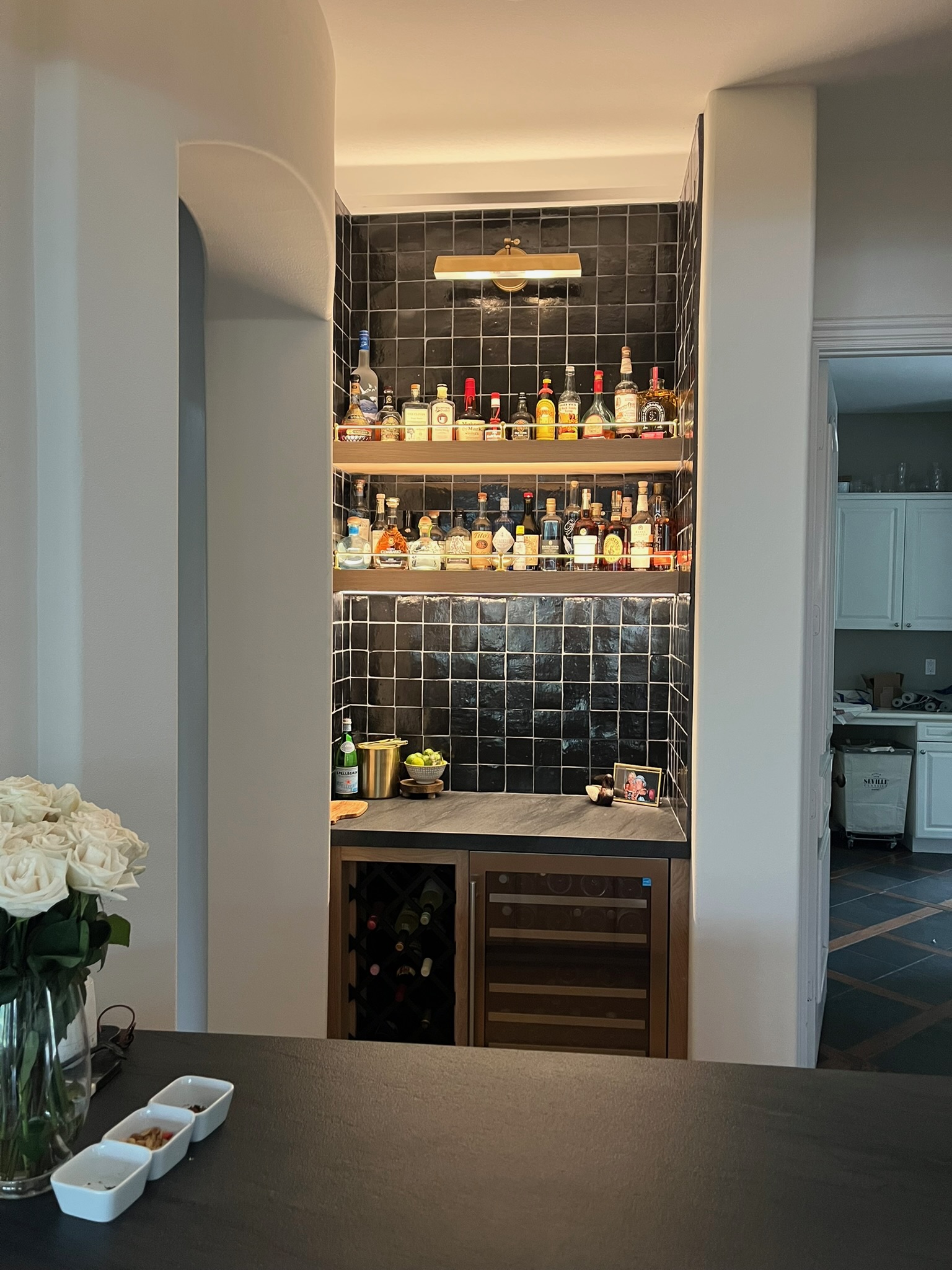 Long galley kitchen with dark cabinetry and glass display