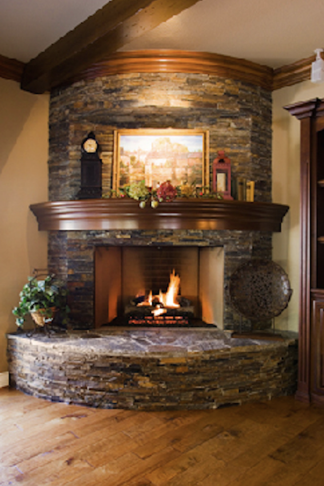 Stacked-stone corner fireplace with curved mantel