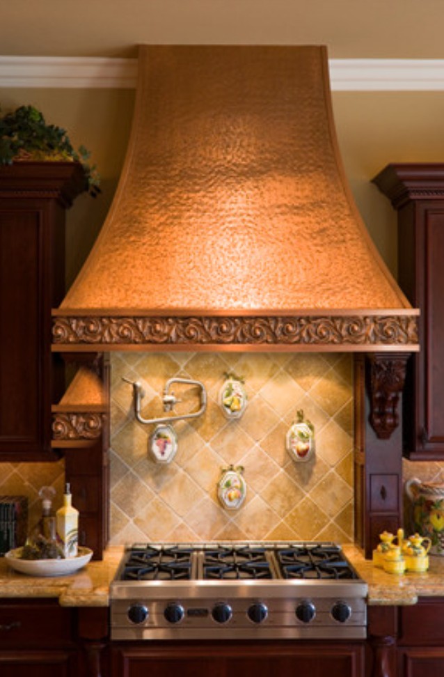 Hammered copper range hood with tile backsplash